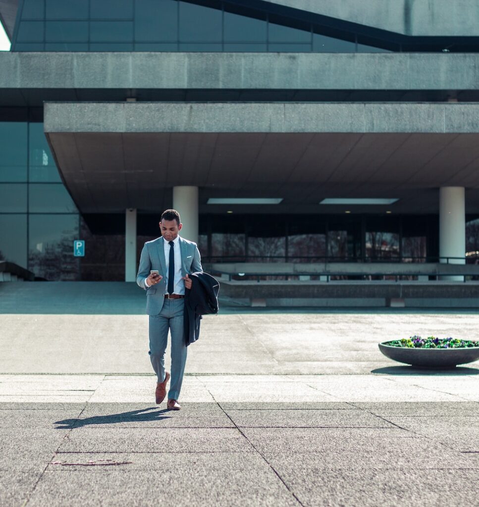 man walking while holding black coat